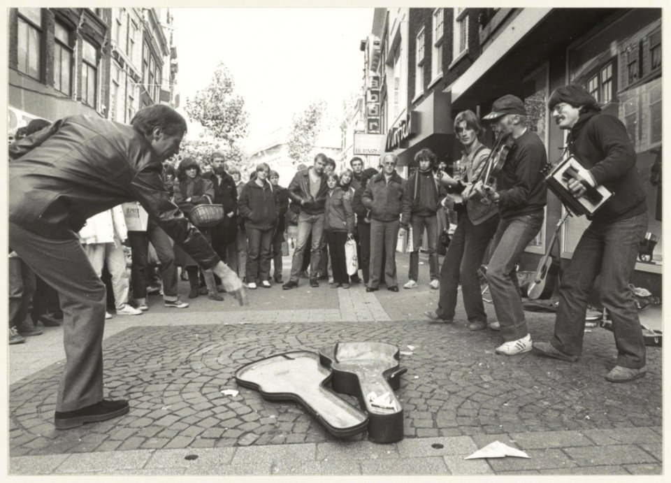 Straatmuzikanten. Het trio Overlast in de Grote Houtstraat. Muzikanten v.l.n.r. Henk Heijlema, Ben Sikken en Rien de Bruin, NL-HlmNHA 54011482