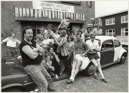 Straathoekwerker Fer Versteeg met jongeren van de Indischebuurt-Noord voor het alternatieve buurthuis 'Humpy's' snackbar in de Kedoestraat. NL-HlmNHA 54013197