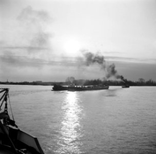 Stoomsleper met binnenvaartschip op de Waal bij zonsondergang, Bestanddeelnr 254-0935