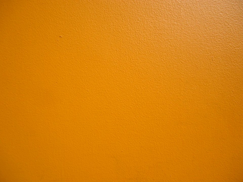 Surfaces exterior wall of a restaurant painted orange closeup view
