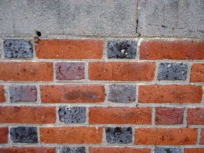 Surfaces brick wall multicolor bricks topped by stone closeup view photo