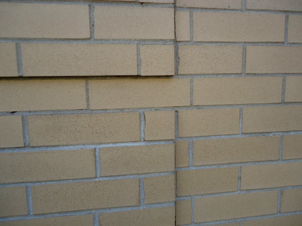Surfaces brick wall closeup view with some bricks jutting out