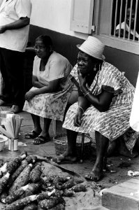 Suriname, marktleven twee vrouwen bij hun koopwaar, jongen maakt vis schoon, Bestanddeelnr 927-8433