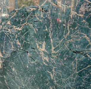 Surface exterior vertical wall granite or marble with reflections of cars closeup view
