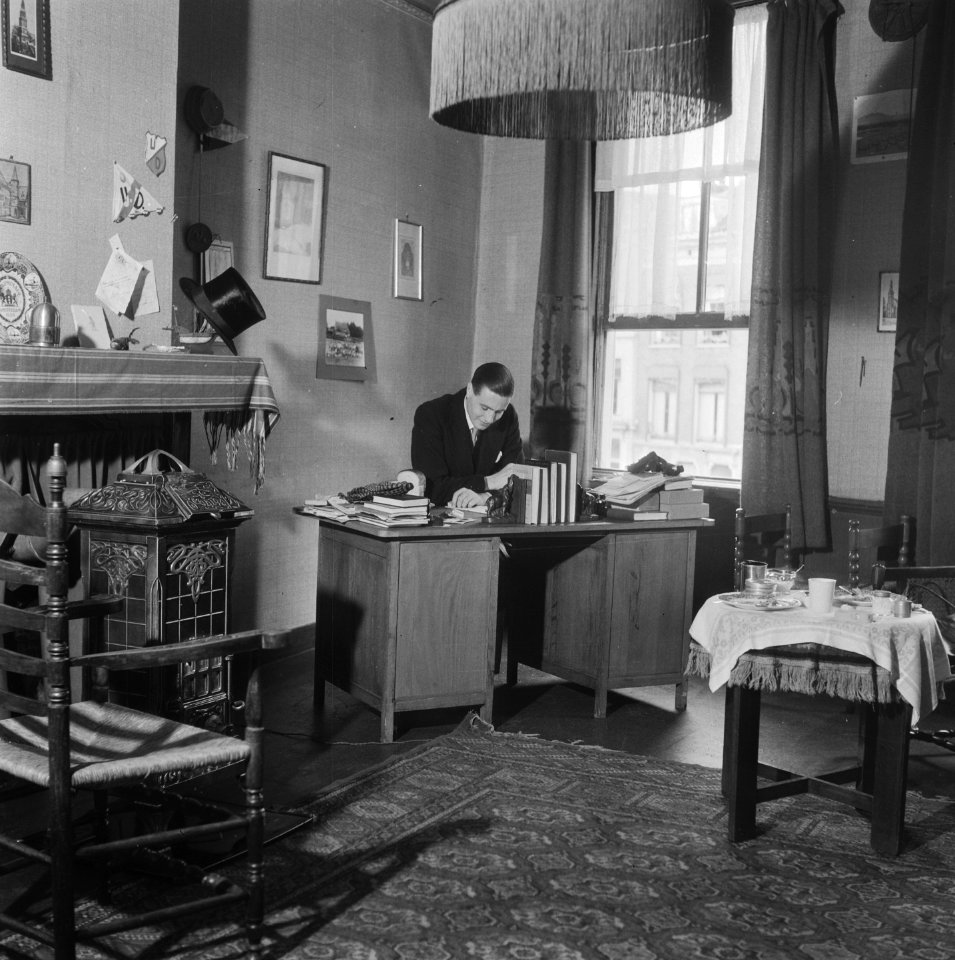 Student achter een bureau in zijn studentenkamer, Bestanddeelnr 900-8002