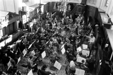 Studenten Orkest oefent in kerk van Bergen. De paukenist met ijsmuts maakt handi, Bestanddeelnr 920-9737
