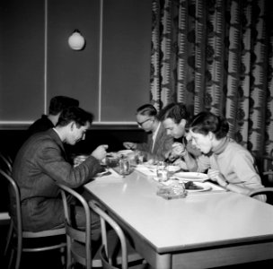 Studenten aan tafel in de eetzaal van het studentenhuis, Bestanddeelnr 252-8946 photo