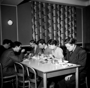 Studenten aan tafel in de eetzaal van het studentenhuis, Bestanddeelnr 252-8947 photo