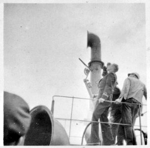 Stuurman van een bewapend koopvaardijschip kijkt naar de lucht, Bestanddeelnr 935-3195