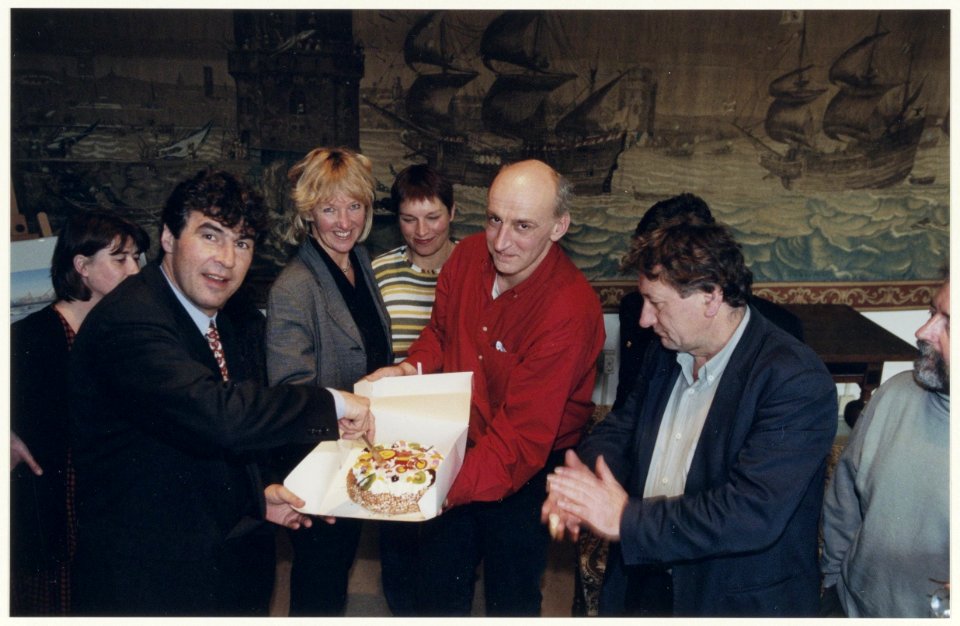 Staflid Matthieu Beaumond en medewerkers van het met sluiting bedreigde Crisiscentrum overhandigen een taart aan wethouder M. de Vries t.g.v. het 20-jarig bestaan. NL-HlmNHA 54036928