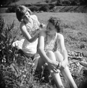 Stiefdochters Renée en Hans zonnebadend op een grasveld, Bestanddeelnr 191-0575