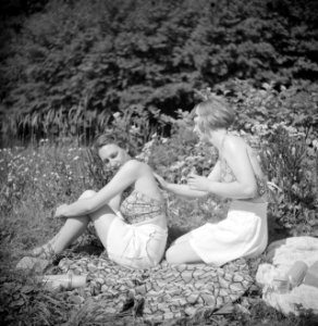 Stiefdochters Renée en Hans zonnebadend op een grasveld, Bestanddeelnr 191-0615