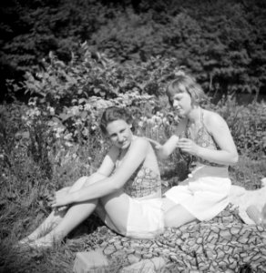 Stiefdochters Renée en Hans zonnebadend op een grasveld, Bestanddeelnr 191-0577