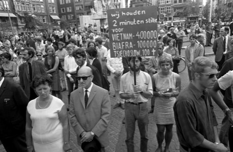 Stilte op de Dam in Amsterdam. Tussen de herdenkende mensen ook een demonstrant, Bestanddeelnr 921-6273