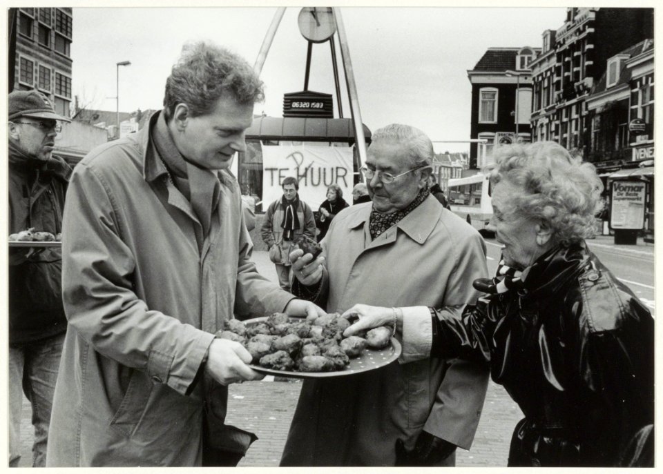 Stichting Millennium deelt oliebollen uit als actie tegen leegstand van het monument van de 20ste eeuw. NL-HlmNHA 54037033