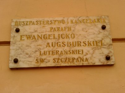 Tablica informacyjna Duszpasterstwa i Kancelarii parafii protestanckiej na kamienicy pod adresem Strumykowa 10 w Toruniu