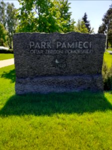 Tablica kamienna na wejściu do Parku Pamięci Ofiar Zbrodni Pomorskiej z 1939 roku w Toruniu