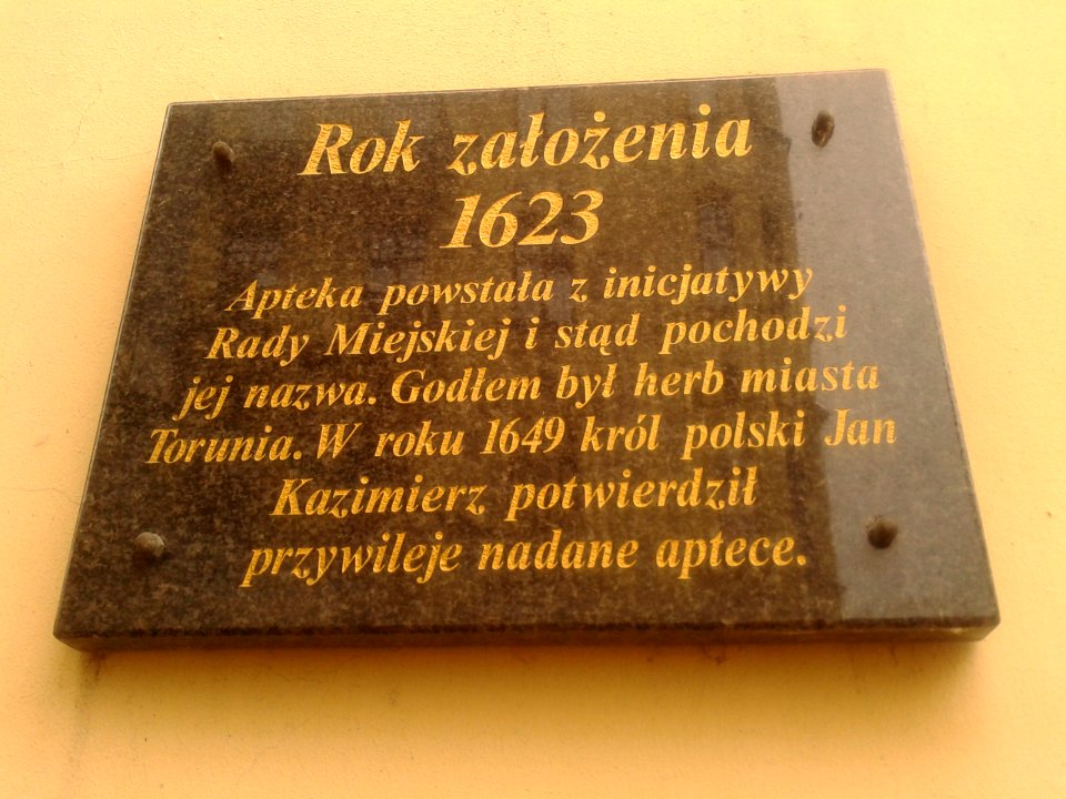 Tablica pamiątkowa na zewnętrznej ścianie Apteki Radzieckiej w Toruniu