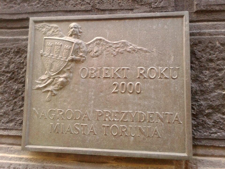 Tablica Obiekt Roku 2000 na kamienicy pod adresem Małe Garbary 7 w Toruniu