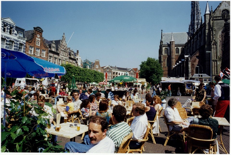 Terraszitters op de Grote Markt, ziende naar het oosten. NL-HlmNHA 54035197