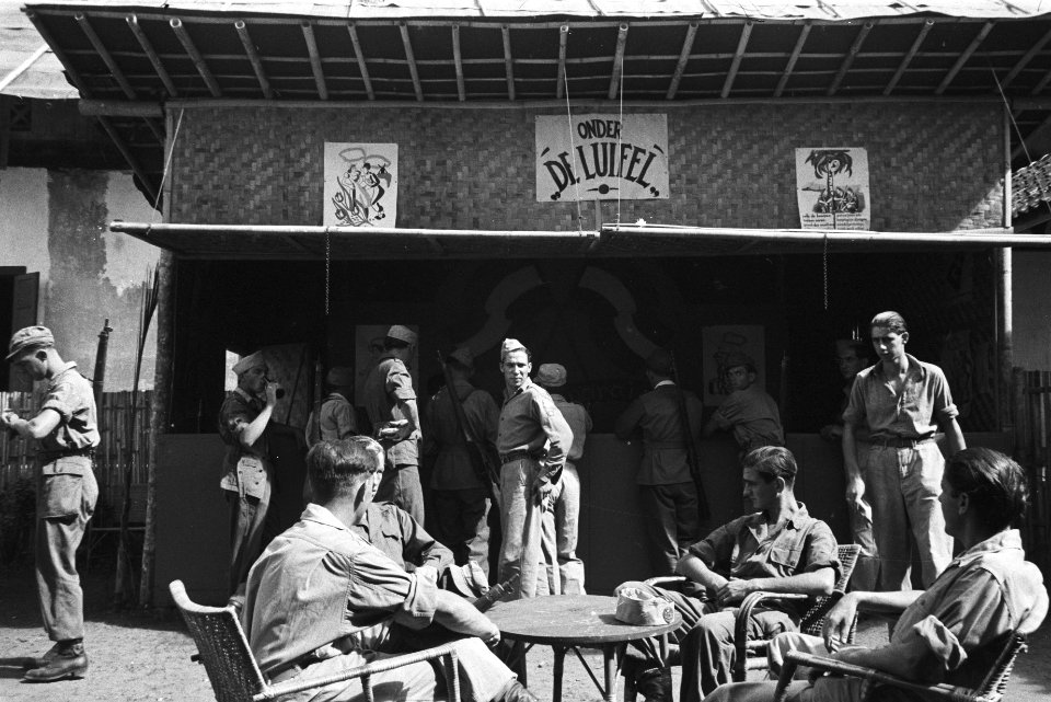 Terras met militairen. Te zien is de bar Onder de Luifel, Bestanddeelnr 513-3-4