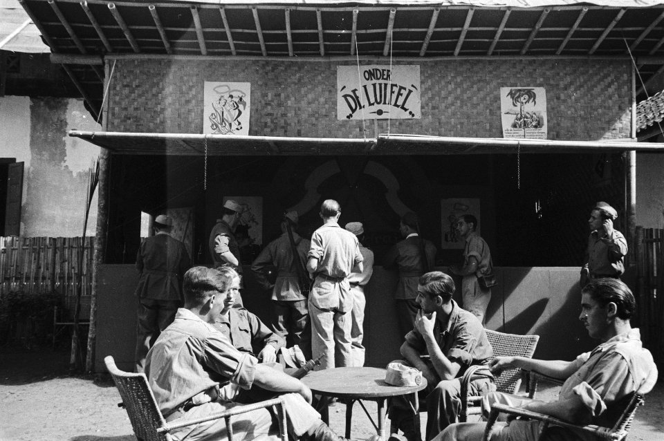 Terras met militairen. Te zien is de bar Onder de Luifel, Bestanddeelnr 513-3-5