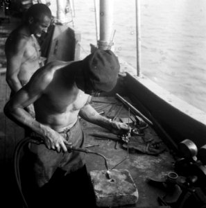 Telefoonkabels leggen op zee. Een lasser is bezig met een bout, Bestanddeelnr 8040