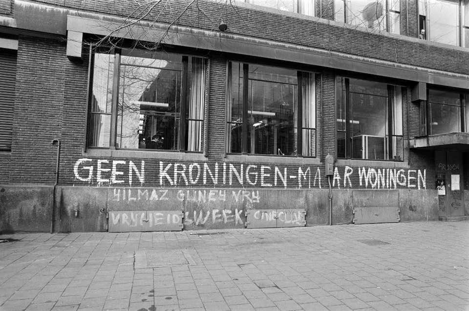 Tekst Geen koningen maar woningen op muur gebouw van PTT Tele communicatie in, Bestanddeelnr 930-7148