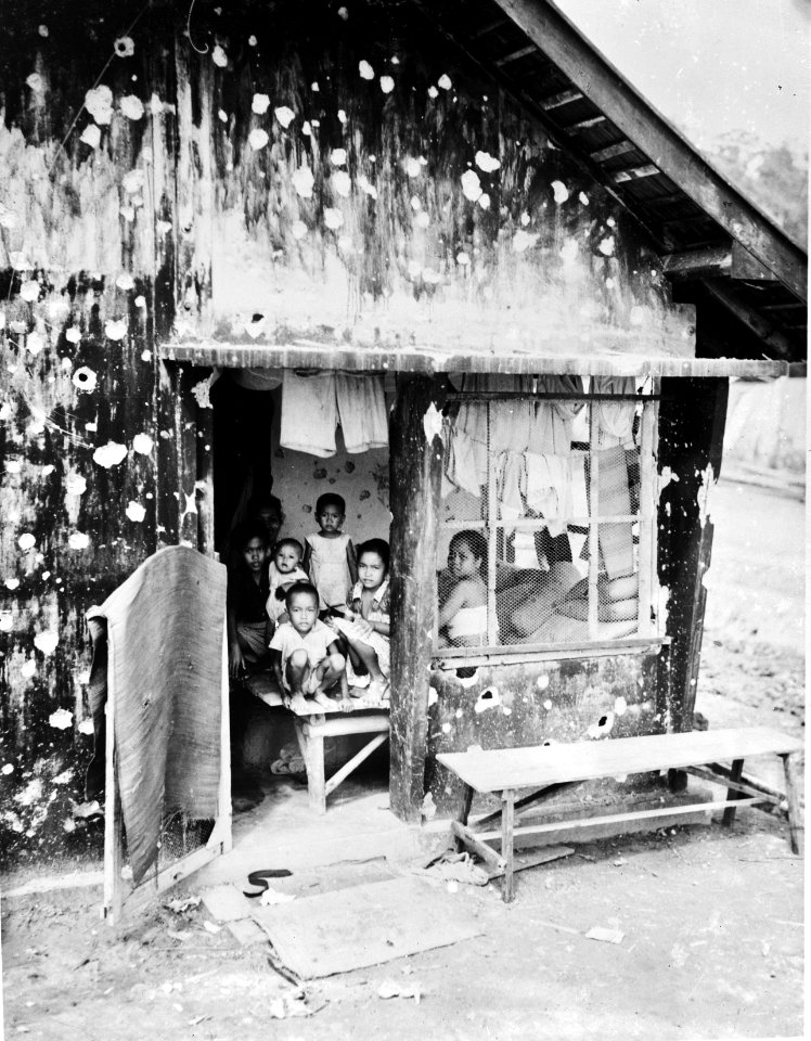 Tarakan (Borneo, Nederlands-Indië) Een gezin in een door kogels doorzeefde ba, Bestanddeelnr 900-7280