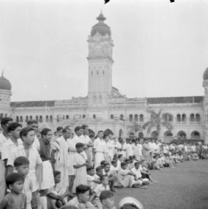Toeschouwers bij een voetbalwedstrijd voor het Parlementsgebouw in Kuala Lumpur, Bestanddeelnr 255-6656