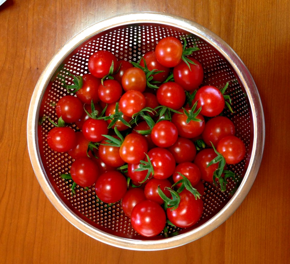 Tomatoes in a punching metal bowl