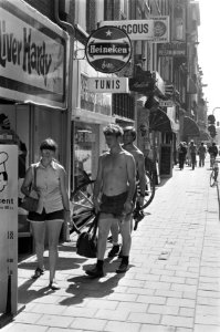 Toeristen met ontbloot bovenlijf wandelen door de binnenstad, Bestanddeelnr 928-0824