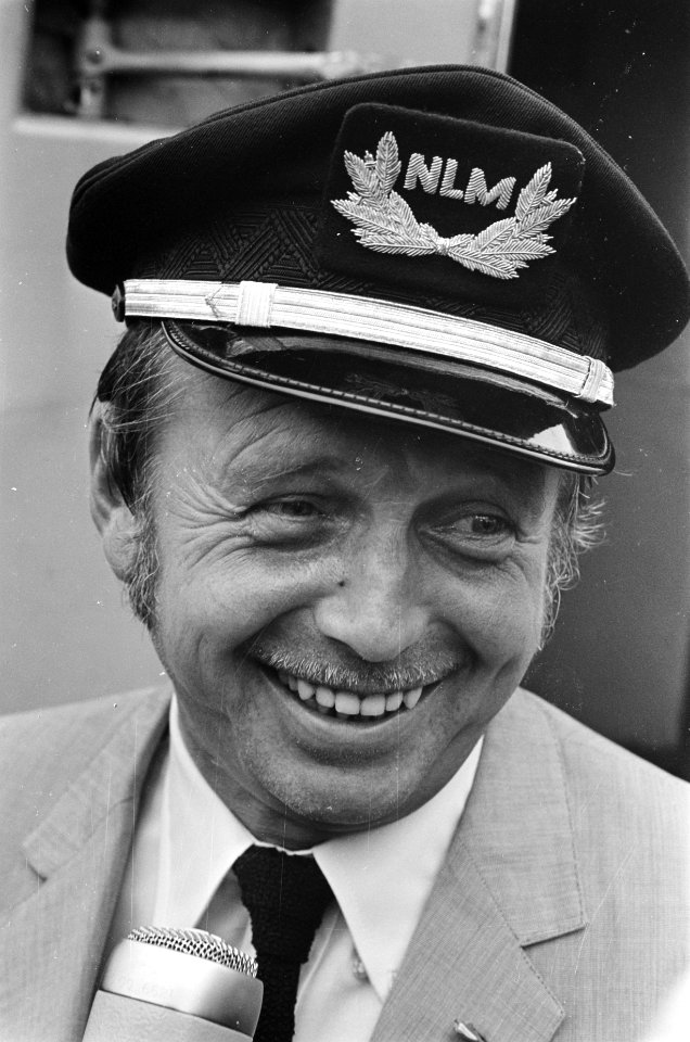 Toon Hermans vliegt voor het eerst. Toon met pet van piloot bij aankomst op Schi, Bestanddeelnr 921-4477
