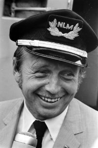Toon Hermans vliegt voor het eerst. Toon met pet van piloot bij aankomst op Schi, Bestanddeelnr 921-4477