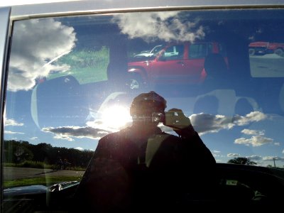 Tom Sulcer photographing reflection in car glass at park