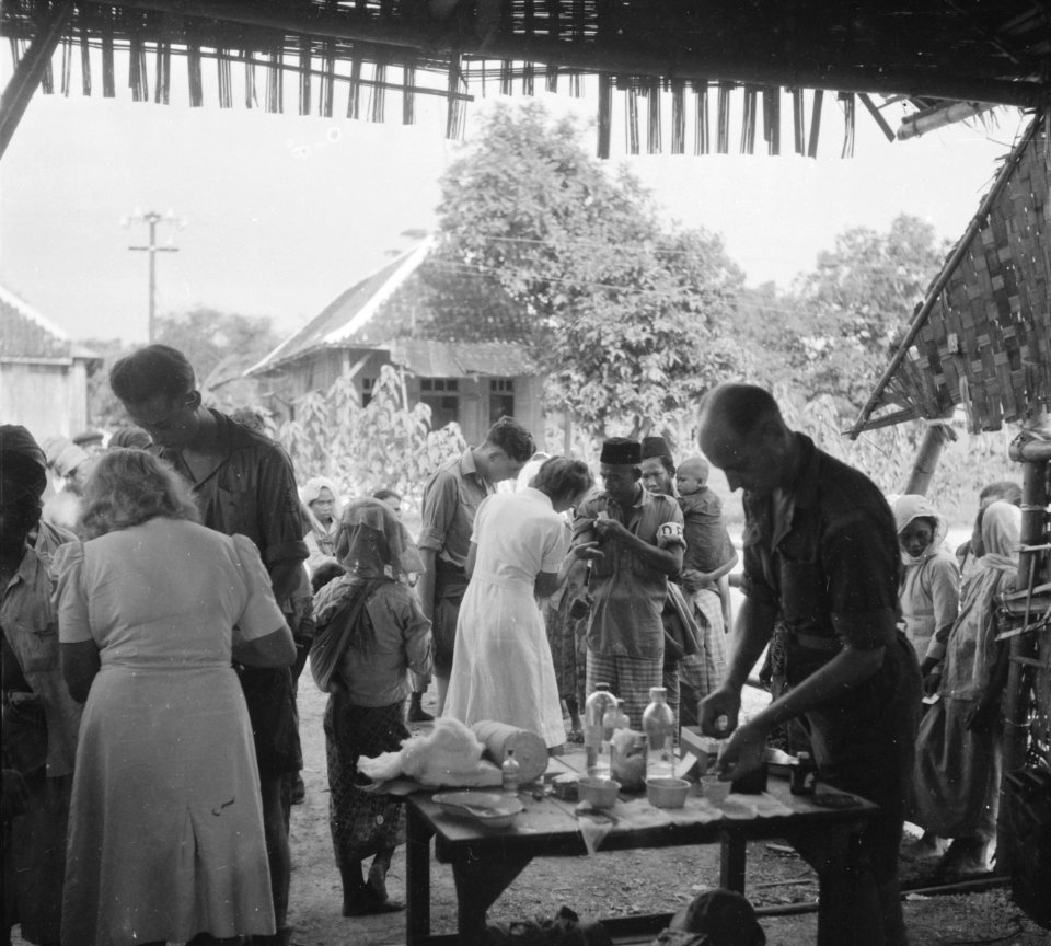 Tjermee. De bataljonsarts met zijn Rode Kruis zuster aan het werk in de kampong, Bestanddeelnr 12349