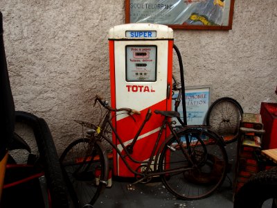 Total, old petrol pump with bicycle parked in front of it