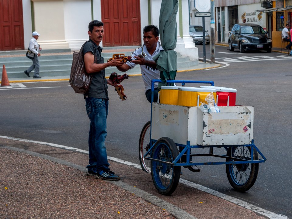 Toy car salesman showing a craft chicha vendor