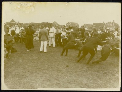 Touwtrekwedstrijd tussen twee damesteams op een open veld in een dorp met een en, Bestanddeelnr 158-1251