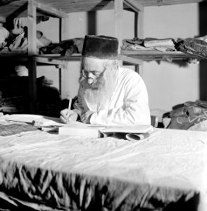 Thora-schrijver aan het werk achter een werktafel, Bestanddeelnr 255-2351