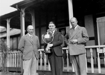 Three men outside Llandrindod Golf Club pavilion, one holding a "... Challenge Cup" (1294729)