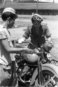 Twee Indonesische mannen sleutelen aan een motorfiets De linker heeft de afkort, Bestanddeelnr 317