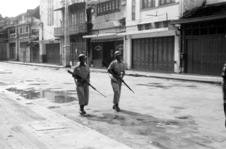 Twee gehelmde TNI militairen lopen door een lege straat met hun geweren in de aa, Bestanddeelnr 887