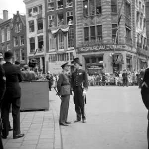 Twee functionarissen, in militair tenu (l) en ambtskledij (r), bij de perstribun, Bestanddeelnr 255-7134