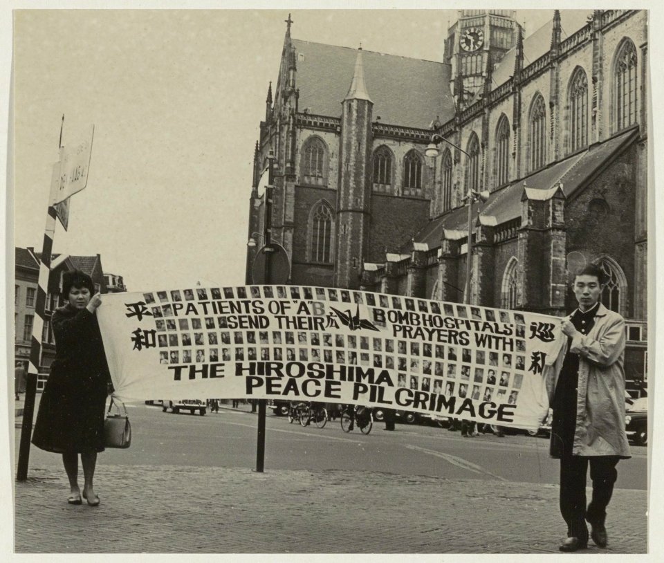 Twee Japanse demonstranten demonstreren tegen de atoombom op de Grote Markt., NL-HlmNHA 54011292