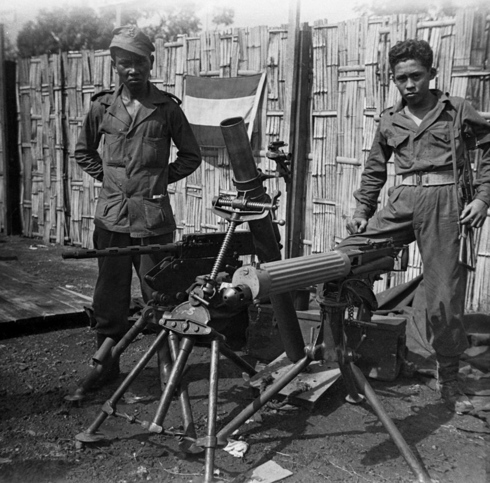 Twee KNIL-militairen poseren bij twee zware machinegeweren en een zware mortier., Bestanddeelnr 10964