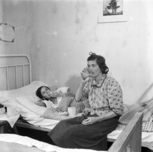 Twee vrouwen drinken en eten. Een van hen ligt op bed, Bestanddeelnr 900-5113