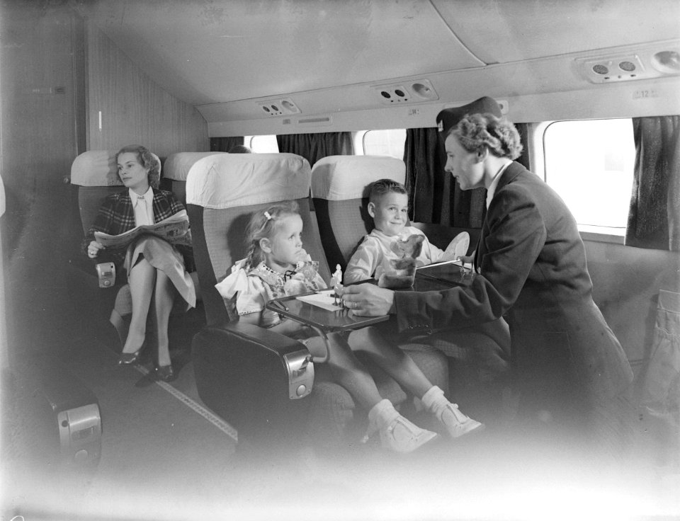 Twee kinderen en een stewardes in een vliegtuig, Bestanddeelnr 254-6150