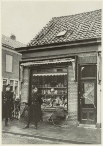 Twee agenten op wacht voor perceel Amsterdamstraat 26 (een winkel van Chr.Koster), na de aldaar gepleegde roofmoord. NL-HlmNHA 54004809