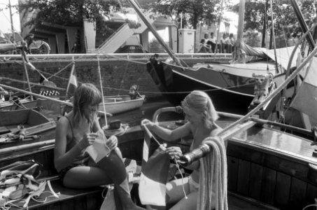 Twee jonge vrouwen zijn bezig de vlaggen in orde te brengen, Bestanddeelnr 928-0974